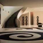 Basement remodeling in White Center featuring a modern finished basement with a curved staircase, contemporary seating, decorative artwork, and elegant lighting design.